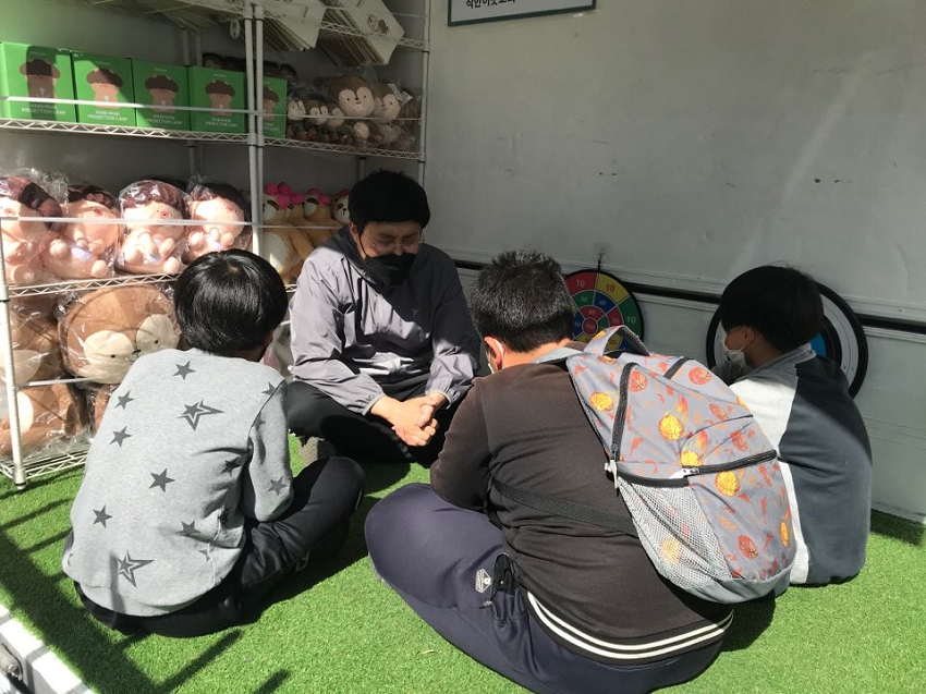 아이들과 무릎이 맞닿은 가스펠트럭