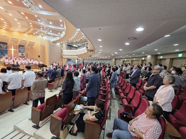 은퇴식 당일, 축하객들 중 기립하여 축하의 예를 표하고 있는 평화교회 성도들. 착석자들은 외부 하객들.